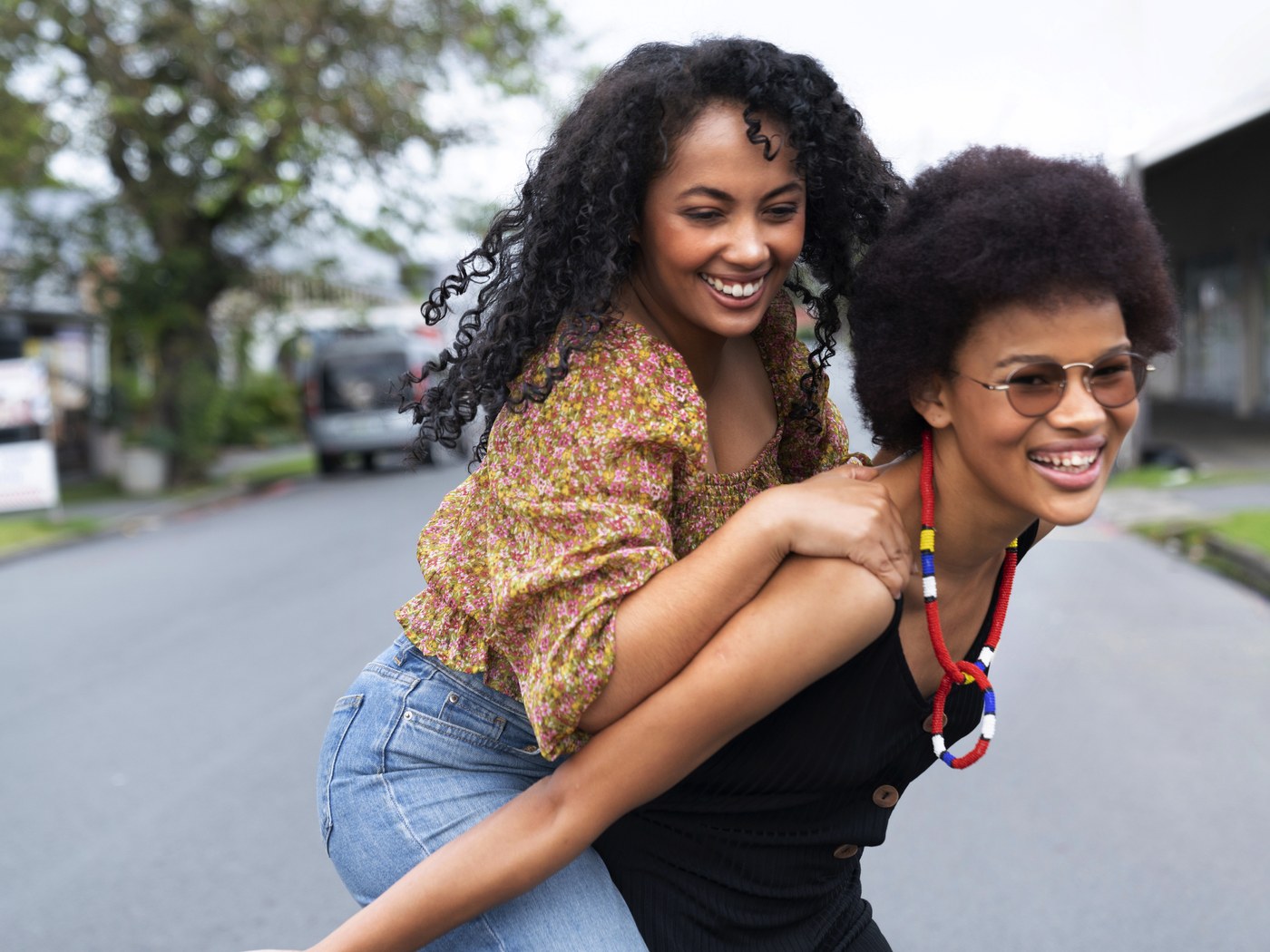 Two friends laughing on a street in town on a Saturday